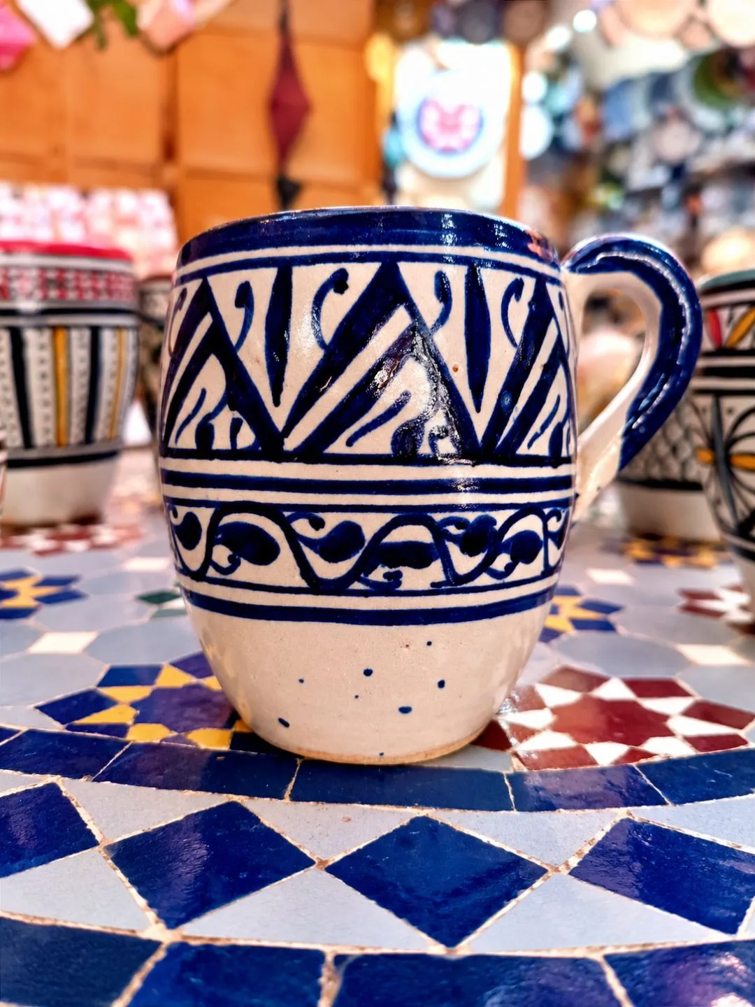Blue and white hand-painted Moroccan pottery mug featuring traditional decorative patterns and a glossy ceramic finish.