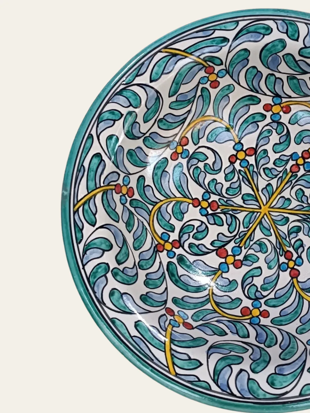Full view of a round Moroccan ceramic plate with a teal rim and multicolor decorative pattern