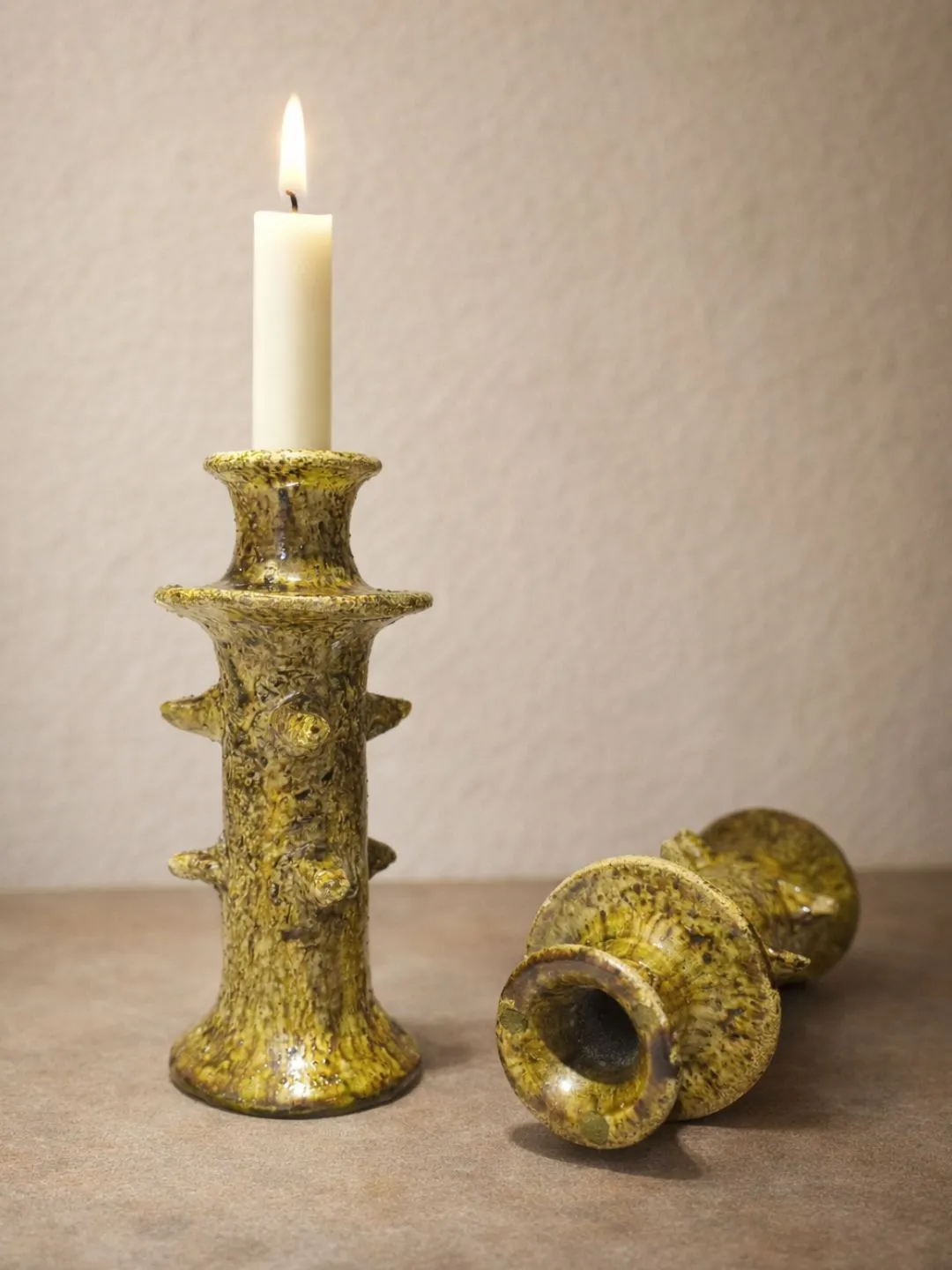 Ochre-yellow Tamegroute ceramic taper candle holder with a white taper candle inserted